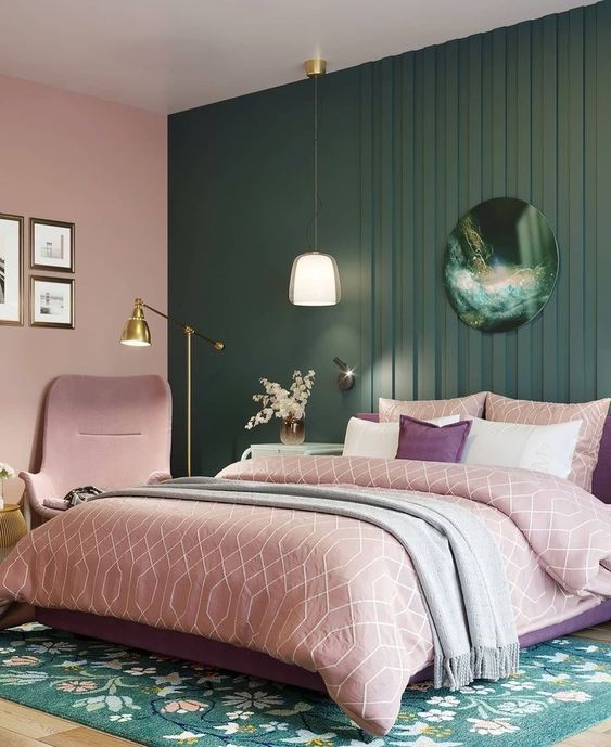 A pink and green bedroom with lights above the bed 