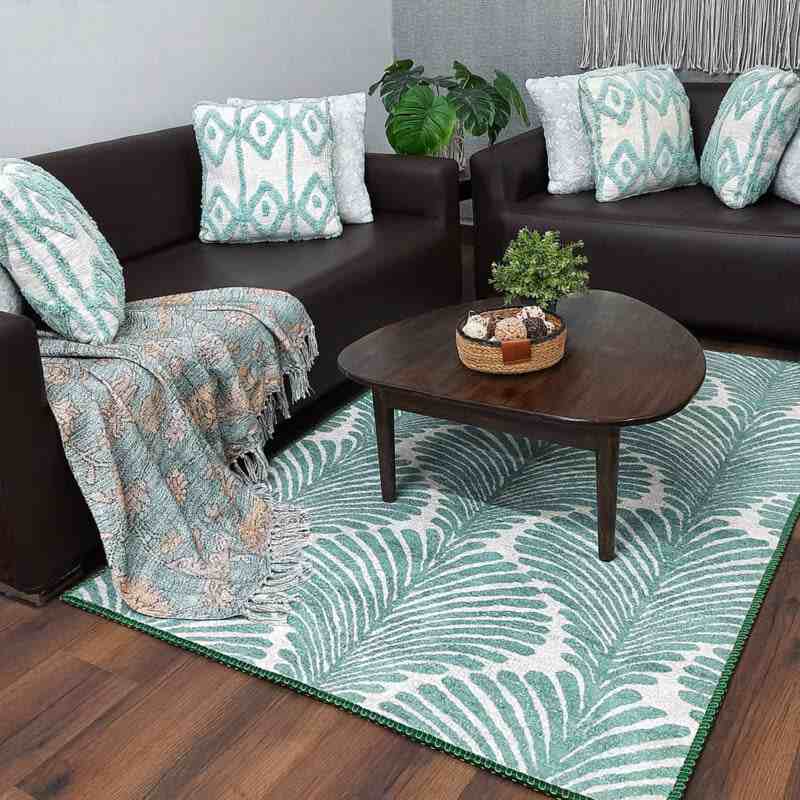 A living room with white and green rug on wooden floor