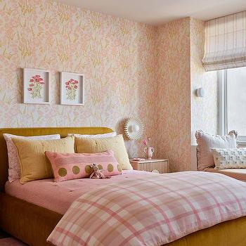 A pink room with white framed and wooden bed