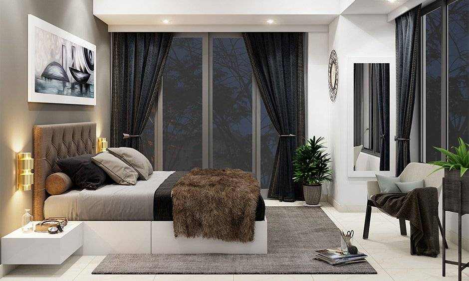 A grey and white bedroom with fixtures lights and brown curtains and mirror on the wall