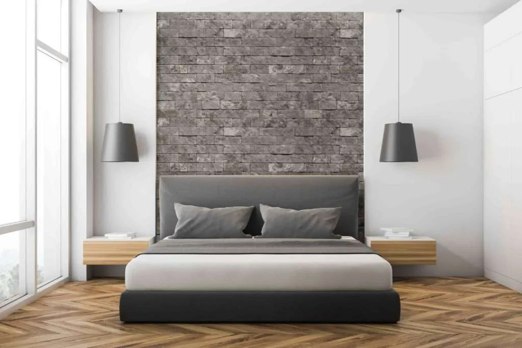 A bedroom with stone wall and wooden floor