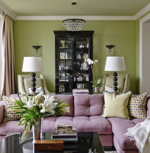 A sage green with lavender room with lamp and table