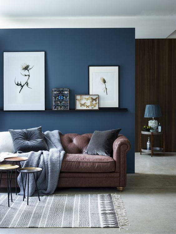 A living room with brown sofa and rug and wooden floor