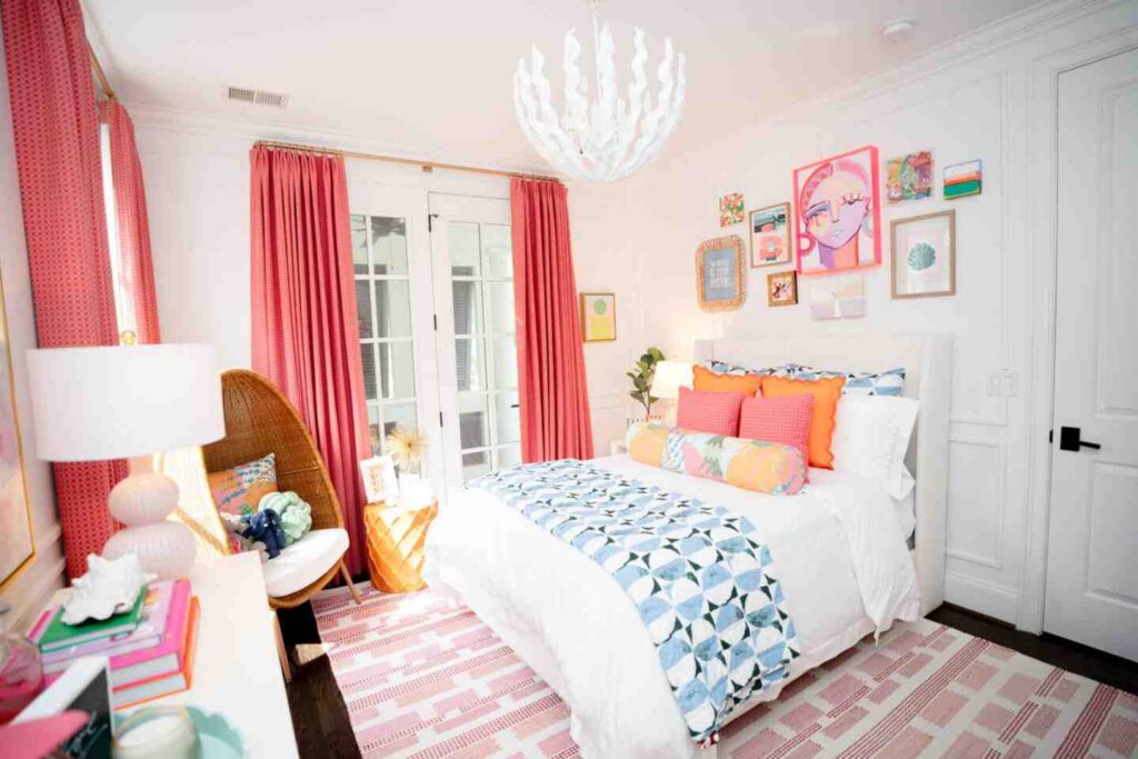 A bedroom with white and pink accents and frames on the wall