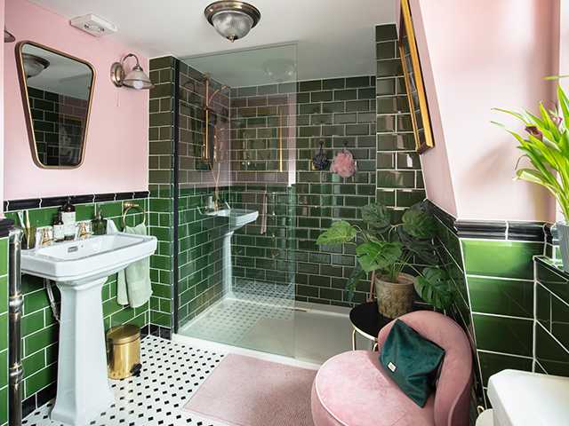 A green and pink bathroom with mirror on the wall and a chair in the bathroom 
