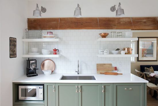 A sage green cabinets and white open shelves