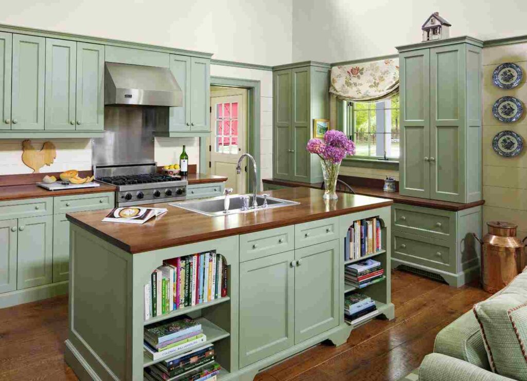A sage green cabinets and wooden counter tp and wooden floor