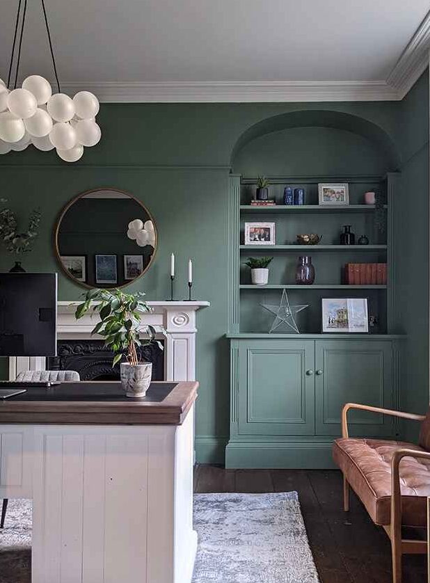 A sage green living with grey celling mirror on wall