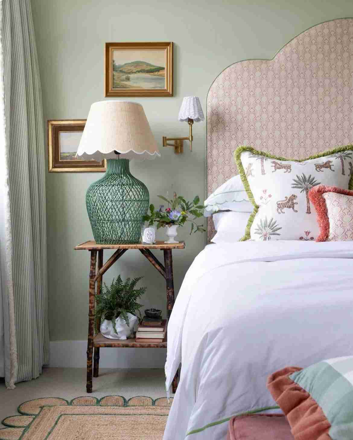 A sage green bedroom with green lamp on the table 
