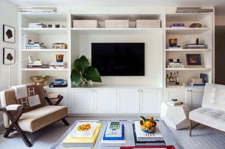 A small living room with shelves and cabinets