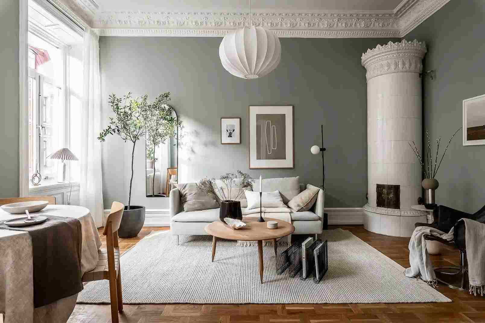 A sage green living room with wooden floor
