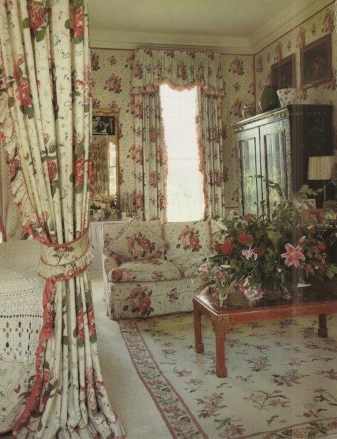 A living room with chintzy florals sofa and curtains and floor