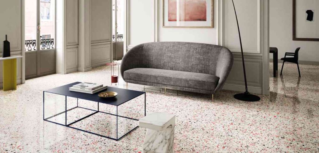 A living room with terrazzo flooring and grey sofa and table