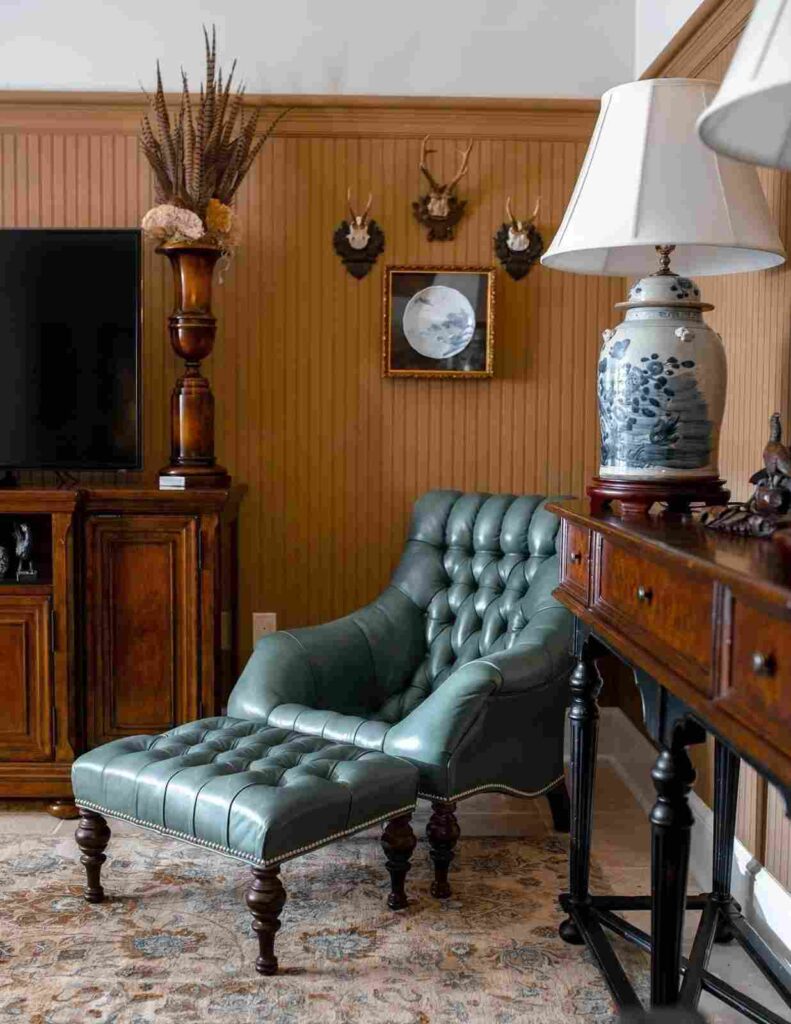 Blue color tufted leather chair and ottoman in a room with wood panel wall