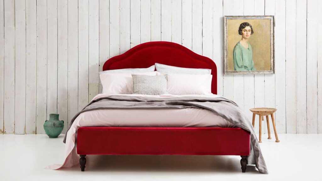 A white bedroom with red headboard
