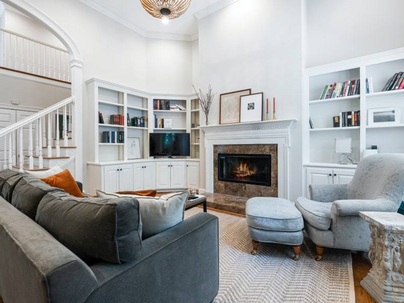 A small living room with vertical space and a fireplace on the wall