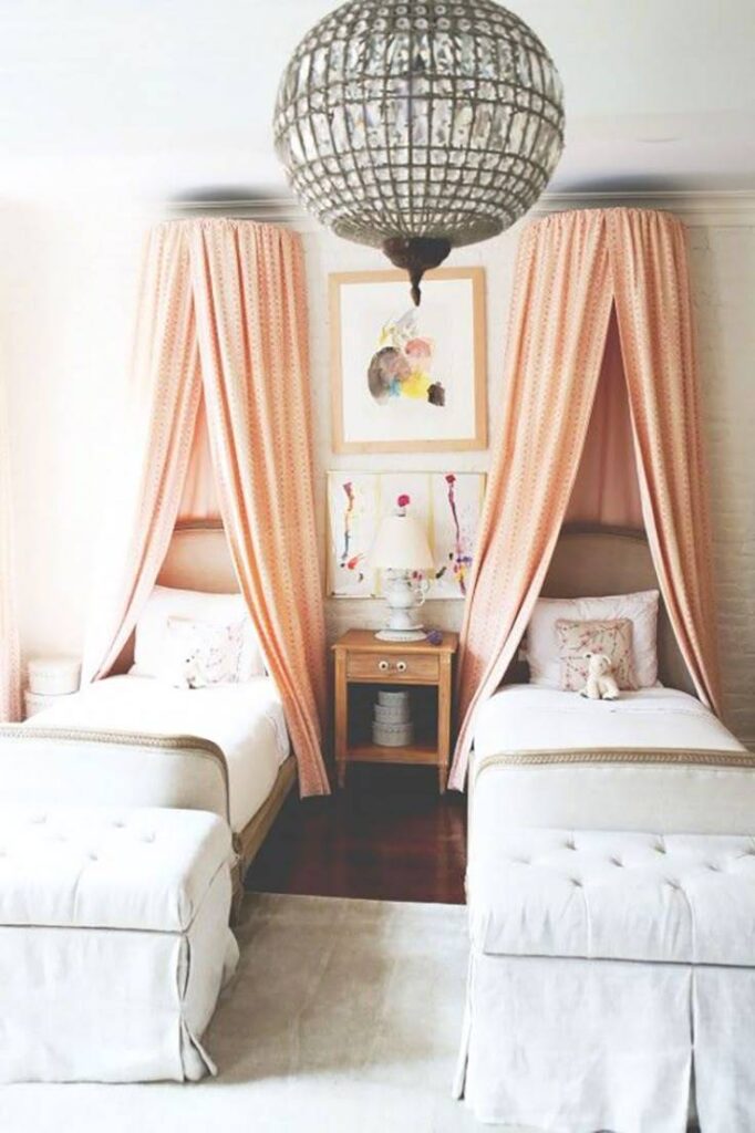 A bedroom with wall canopies on both beds and painting on wall 
