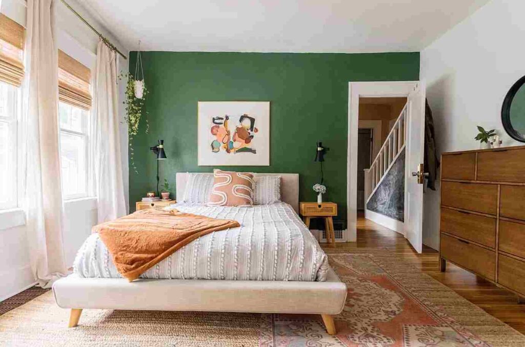 A green bedroom with white wall and wooden floor with rug and windows 