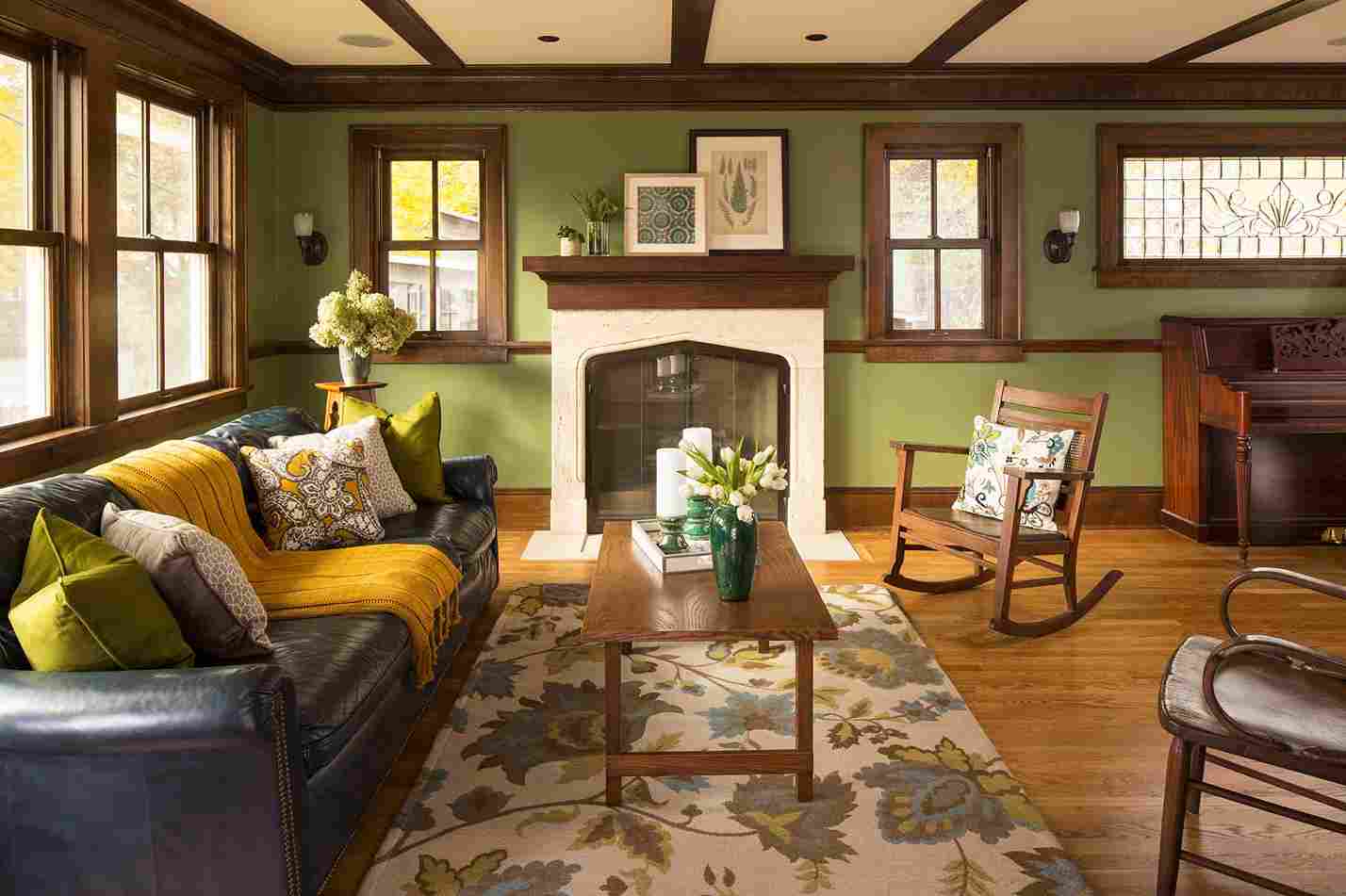 A sage green with brown trim and wooden floor and sofa and table
