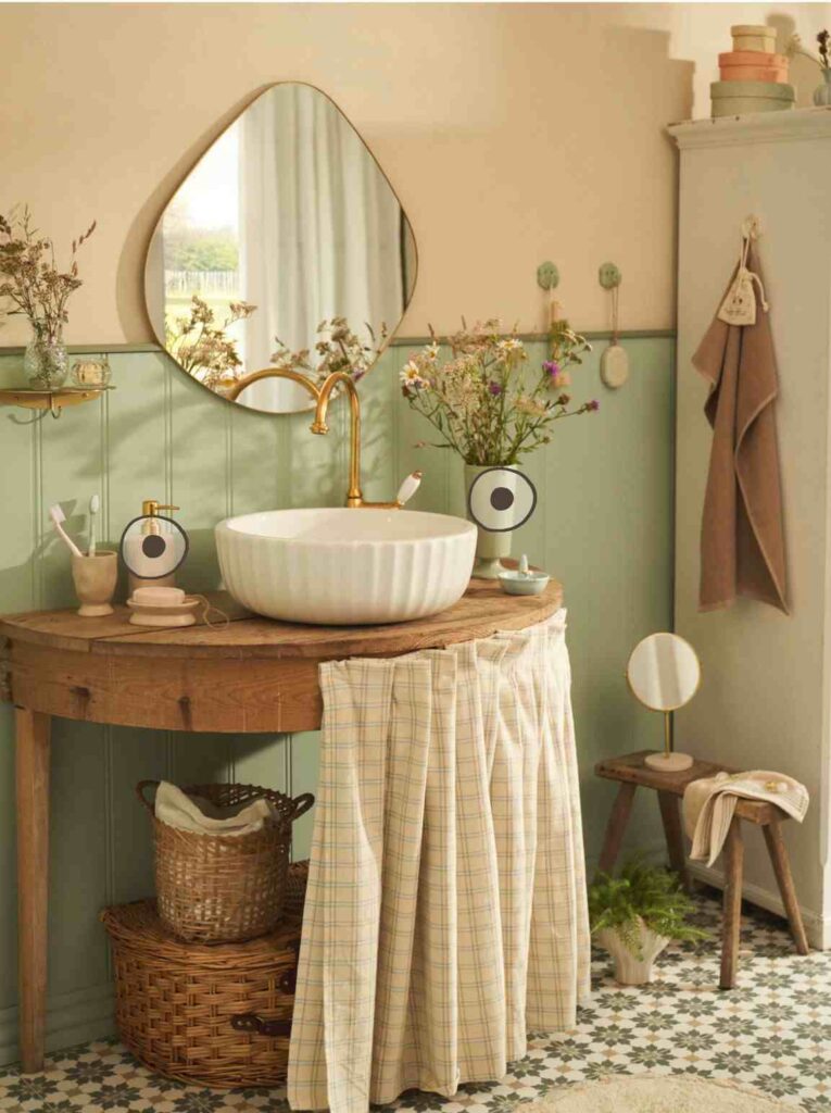 A pink and green bathroom with woven baskets and mirror on the wall
