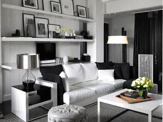 A  black and white living room with white sofa and table 