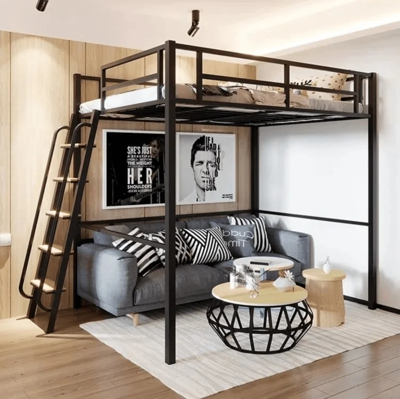 A loft bed with sitting area and frames on the wall 