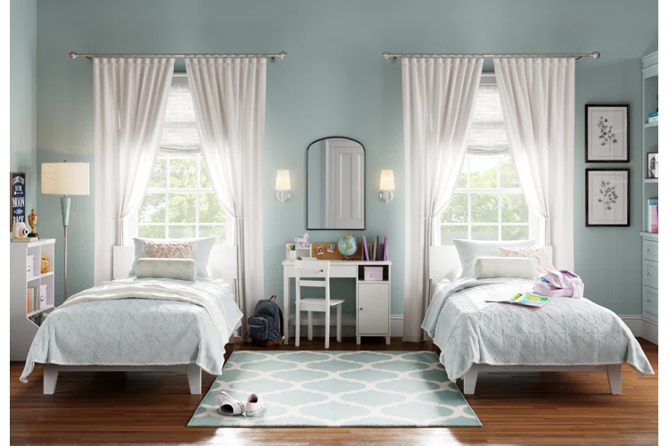 A two beds room with rug on the floor and white window and wooden floor