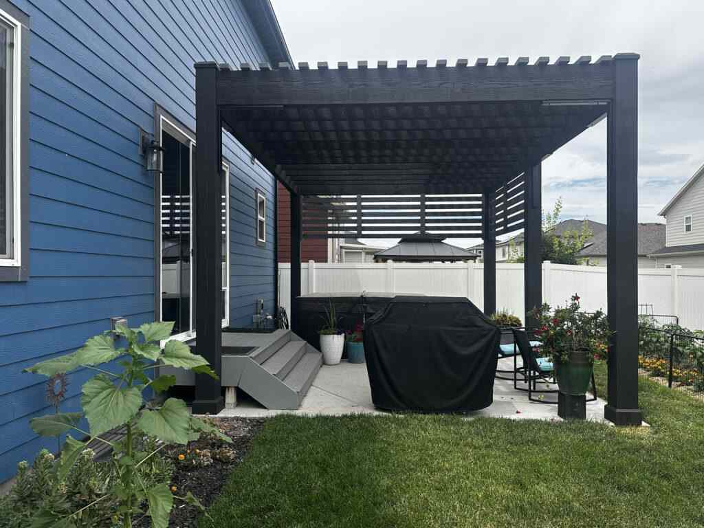 A navy blue house with black pergola 