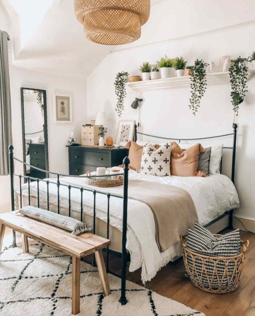A bedroom with iron frames bed and woven basket and wooden floor 