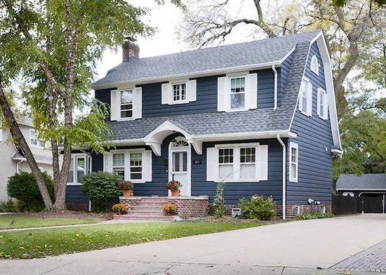 A navy blue house with white door and windows