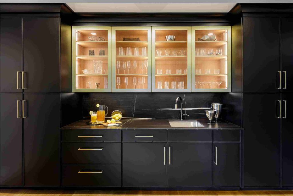 A black kitchen with glass cabinets and wooden floor 