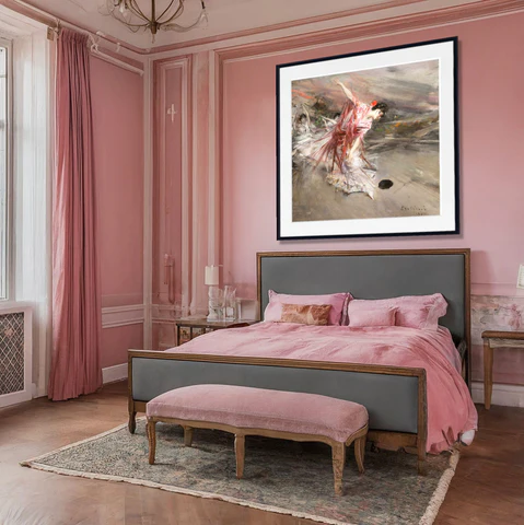 A pink bedroom with frames on the wall and grey bed with blanket and pillow