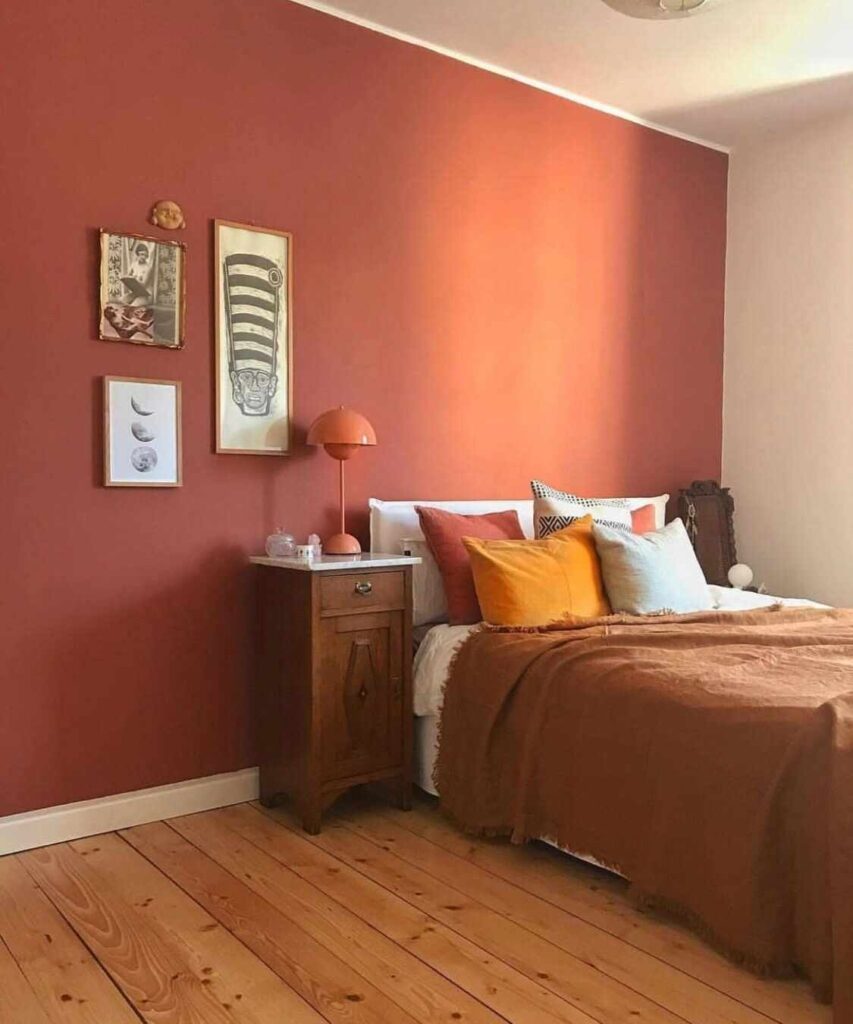 A bedroom with wooden floor and nightstand and lamp on it