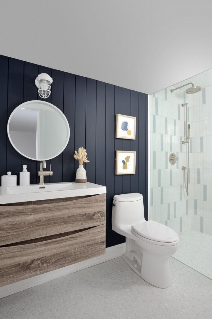 A blue wall in mirror on the wall and wooden vanity white countertop