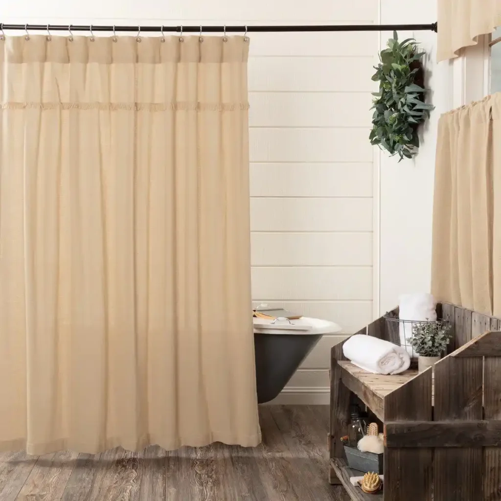 A white bathroom with hang shower curtain and bathroom