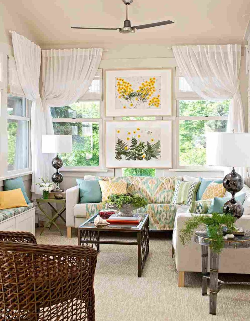 A sunroom hang art in sunroom and sofa and table and curtains 
