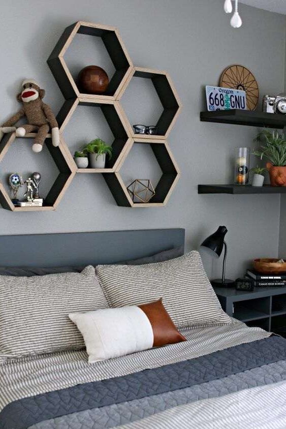 A hexagon shelves on grey wall and grey bedding bed 
