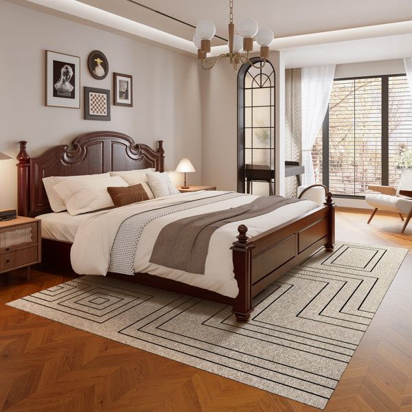 A bedroom with Layer geometric rug on wooden floor and black framed windows 