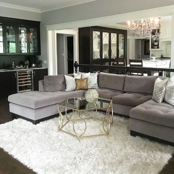A grey living room with white rug and sofa and table 