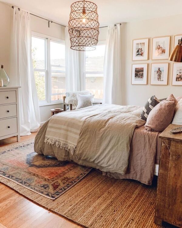 A white bedroom with window and curtain and wooden floor and rug on it