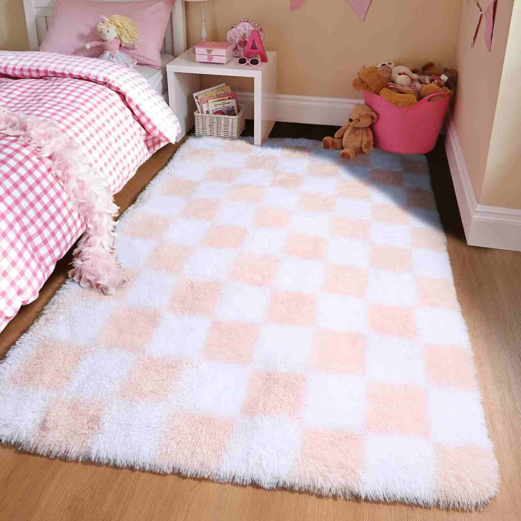 A pink bedroom with white and pink rug on the wooden floor