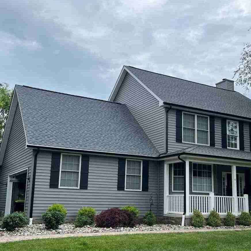 A grey house with black trim and gutters and shutters