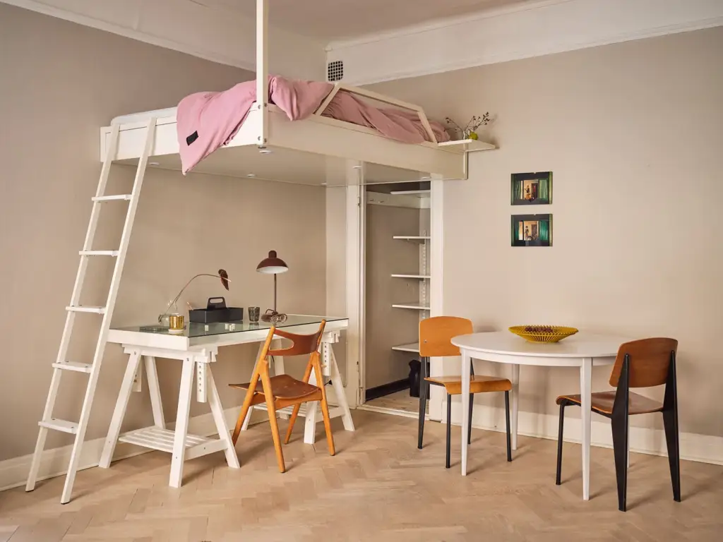 A loft bed in bedroom and chair and table and wooden floor 