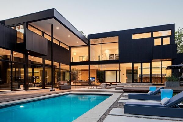 A black glass house with swimming poll