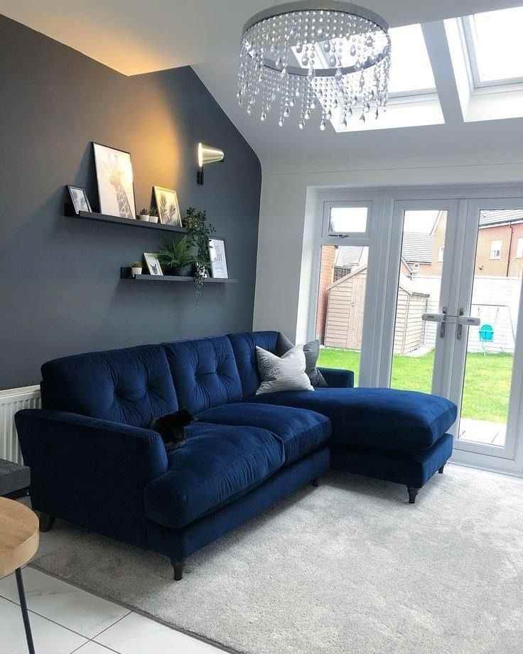 A grey living room with navy blue sofa with cushion on it
