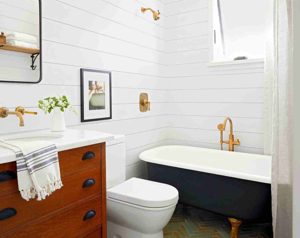 A white bathroom with navy blue bathtub and wooden vanity