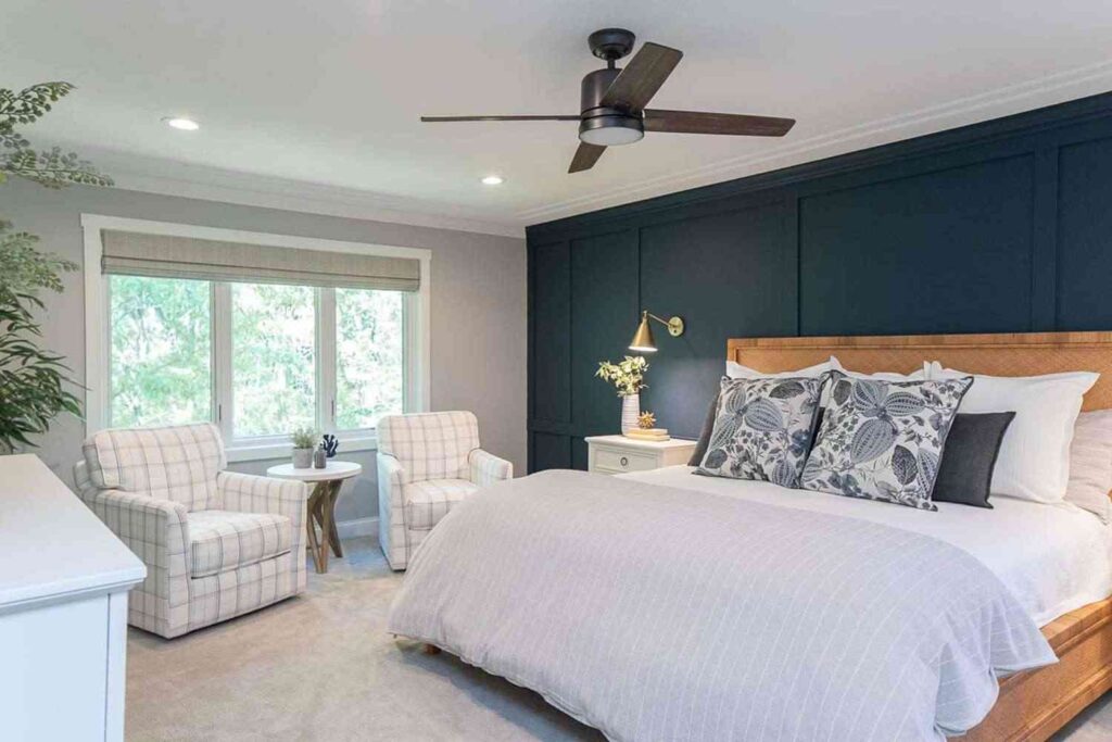 A navy blue wall panel and grey wall and lights and white sofa