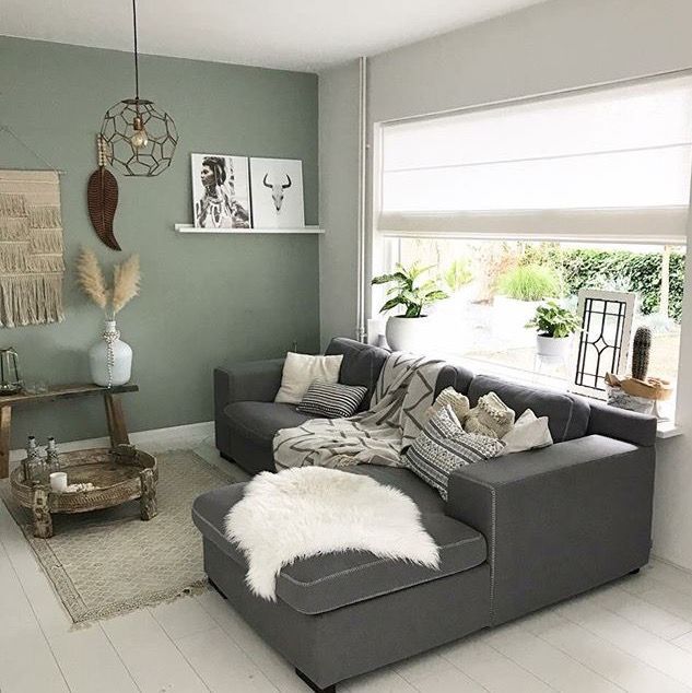 A sage green with gray in living room with windows and painting on the wall 