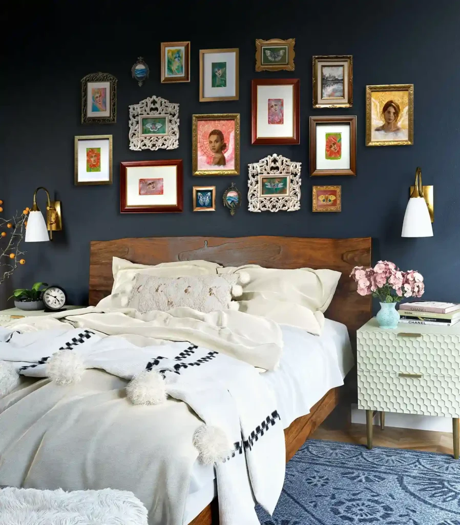 A navy blue bedroom with gallery wall and wooden frame bedding. with white blanket and pillow