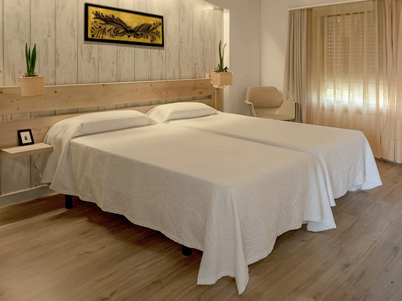 A two bed in one room with wooden floor